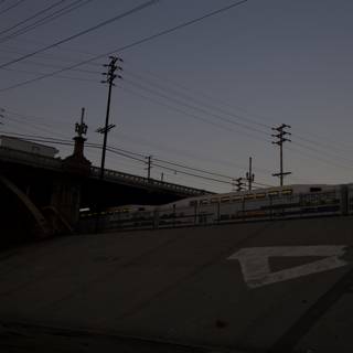 Twilight Train Passing Under Highway Bridge