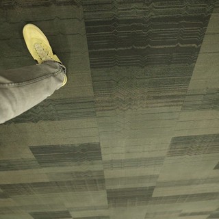 Mid-Step: Sneaker Over Patterned Carpet Tiles