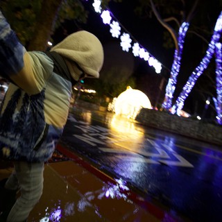 Person Gazing at Illuminated Holiday Display at Night