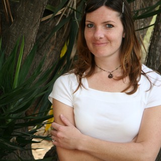 Woman Smiling Beside Tropical Tree Outdoors