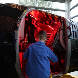 Child Exploring Illuminated Aerospace Engine Display