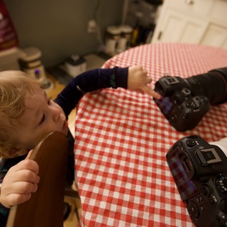 Young Photographer Learning with Two Cameras at Home