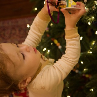Child Decorating Christmas Tree with Ornament