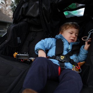 Unhappy Toddler Secured in Black Jogging Stroller