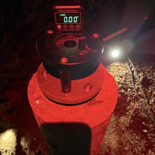 Digital Angle Gauge Zeroed on Red Concrete Pier at Night
