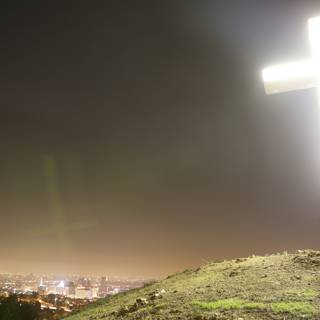Cross on Hill with Cityscape