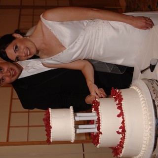 Bride and Groom Cut Three-Tier Wedding Cake Together