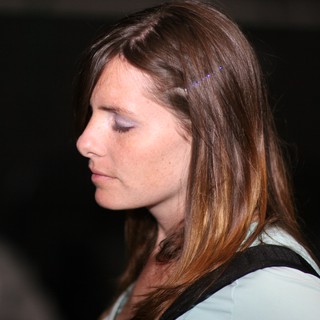 Contemplative Woman in Profile at Dark Venue
