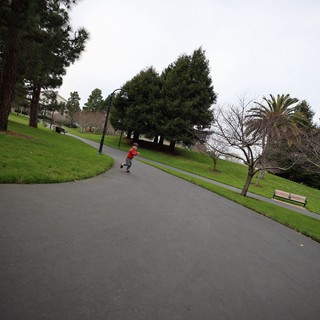 Child Running on Winding Park Path on Overcast Day