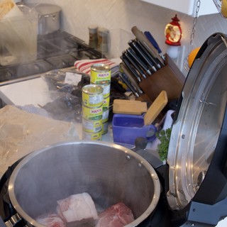 Pressure Cooker with Raw Meat on Cluttered Kitchen Counter