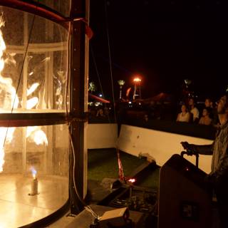 Man Standing in Glass Box Amidst Fire