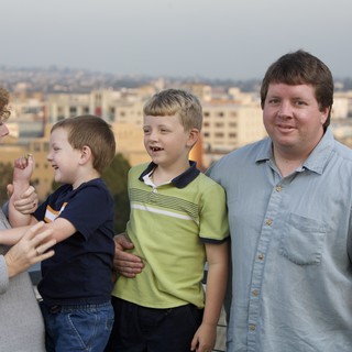 Family Portrait on Rooftop Overlooking City Skyline