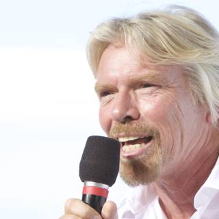 Richard Branson Takes the Stage with a Microphone