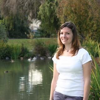 Smiling Woman by a Tranquil Park Pond