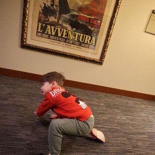 Child Playing Near Classic Film Poster in Lobby