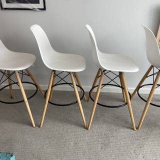 White Bar Stools with Wooden Legs in a Chic Interior Setting