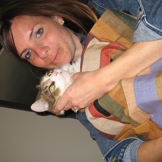 Woman Cuddling Tabby Kitten with Affectionate Smile