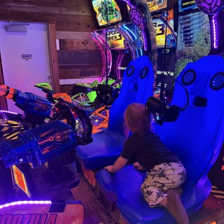 Gamer Playing Virtual Reality Motorcycle Arcade Game