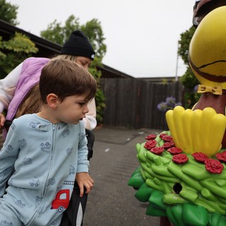 Curious Child Examines Colorful Festival Statue Up Close