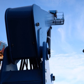 Blue Aerial Lift Platform Against Clear Sky