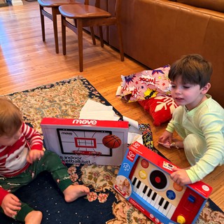 Children Opening Christmas Gifts in Cozy Living Room
