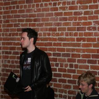 Man with Leather Jacket posing in front of a Brick Wall