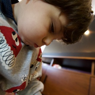 Young Child Focused on Play with Wooden Train Set