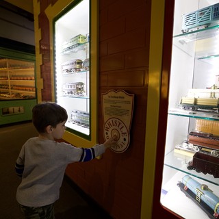 Young Boy Explores Interactive Train Whistle Exhibit at Museum