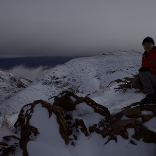 Winter Summit Rest on Snow-Covered Mountain Ridge