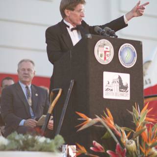 Man in Suit Delivering an Address in Front of a Crowd
