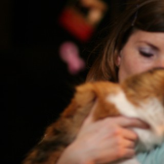 Tender Moment: Woman Nuzzles Orange Tabby Cat