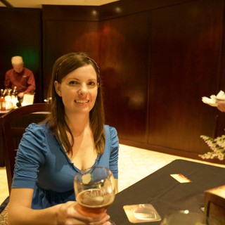 Penelope Smiling with Chimay Beer at Elegant Event