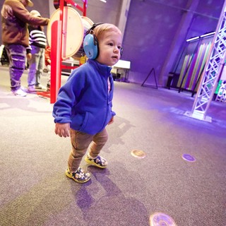 Young Child Exploring Interactive Museum Sound Exhibit