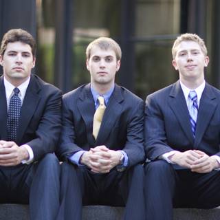 Three Men in Suits Take a Group Shot on Stairs