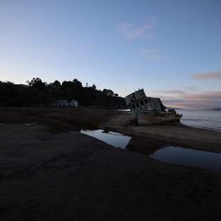 Abandoned Shipwreck at Dusk on Tidal Beach