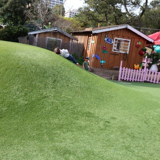 Children Playing on Artificial Turf Hill at Outdoor Playground