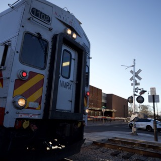 Commuter Train at Railroad Crossing During Twilight