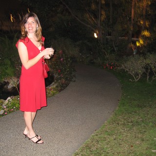 Woman in Red Dress on Garden Pathway at Night