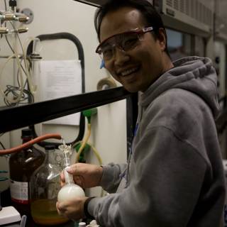 Man in Glasses Holding a Glass Bottle in UCLA Nanotech Lab