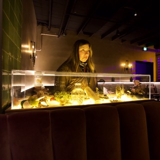 Woman Contemplating Illuminated Aquarium Display at Night