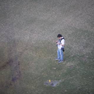 Checking his phone on the grass