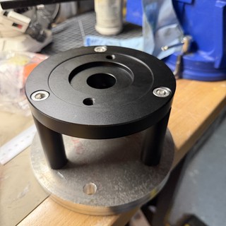 Black Anodized CNC Machined Component on Workshop Table