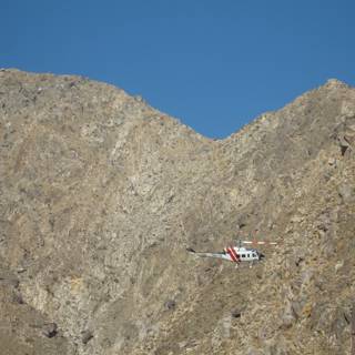 Helicopter soaring over majestic mountain range