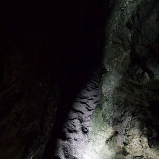 Narrow Cave Passage Illuminated by Single Light