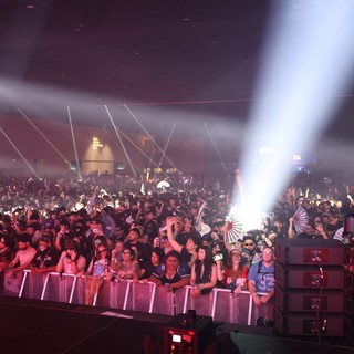 Massive Indoor Festival Crowd Bathed in Stage Lights