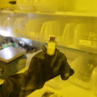 Gloved Hand Holds Small Object in UCLA Quantum Nano Lab