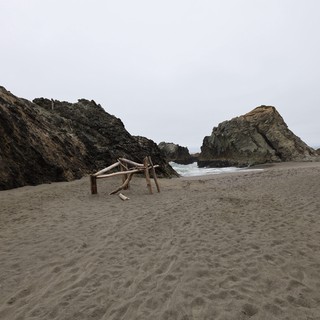 Secluded Coastal Cove with Driftwood Structure