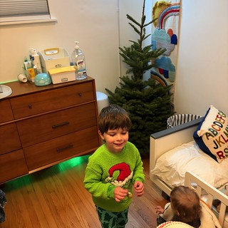 Siblings Decorating Christmas Tree in Cozy Bedroom