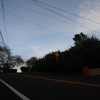 Dusk Road with Power Lines and Yellow Warning Sign