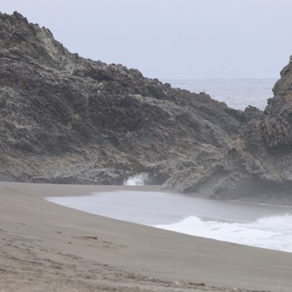 Solitary Figure at Misty Rocky Cove Beach